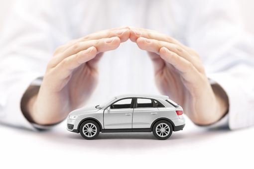 Foto: Hände über kleinem Auto